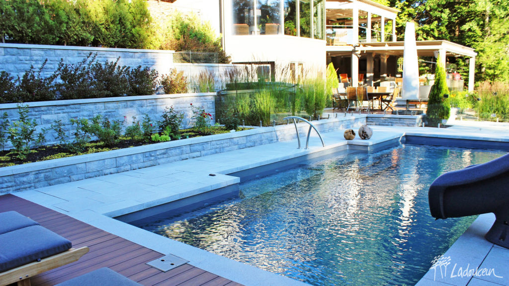 Aménagement paysager de piscine rectiligne avec muret de béton décoratif et terrasse en bois composite Ladouceur