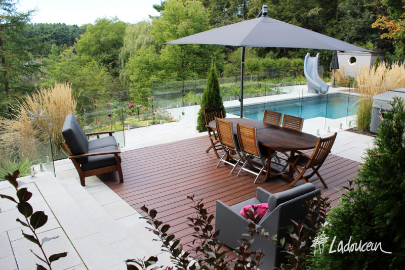 Aménagement de pièces extérieures à aire ouverte terrasse en bois synthetique fibron clôtures de verre piscine