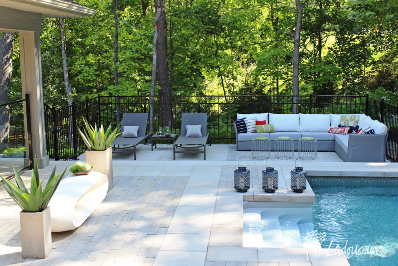 Le mobilier sectionnel est la principale composante du lounge extérieur en bordure d'une piscine