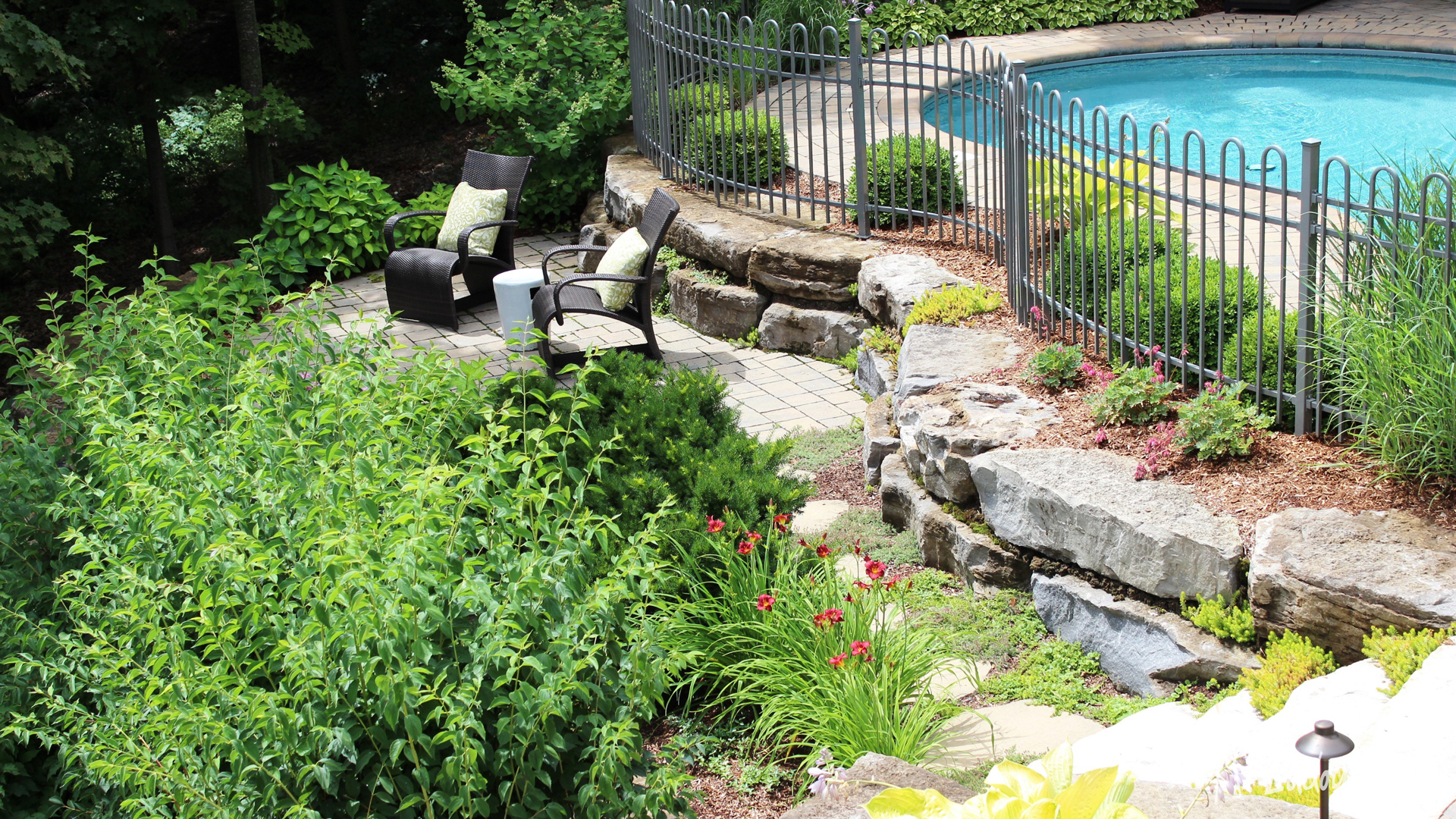 Aménagement paysager et aménagement de piscine champêtre avec roches en pierre naturelle par Ladouceur