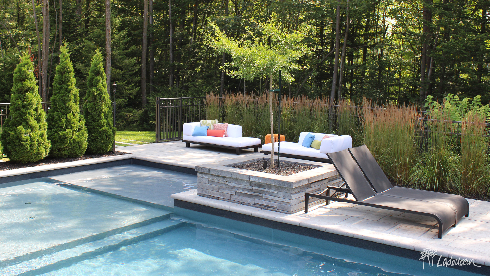 Espace détente en bordure de la piscine avec mobilier lounge et végétaux ladouceur